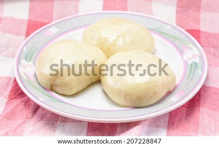 ball of dough for bakery cooking on circle dish at fabric plaid background