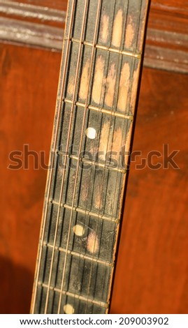old Guitar acoustic Frets on wood wall  background at sunshade