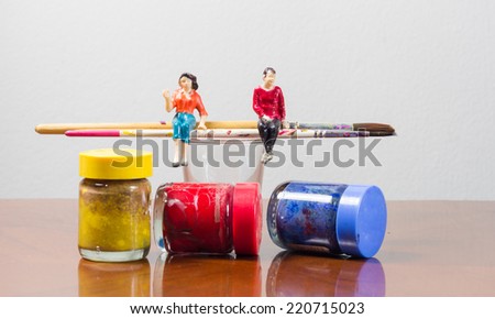 Miniature people sitting on paint brush concept art painting tool