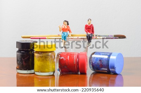 Miniature people sitting on paint brush concept art painting tool