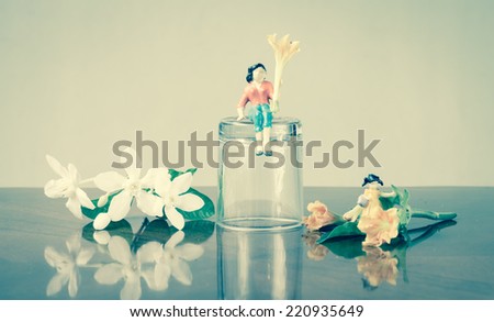 miniature family people with a flower  concept resting day and retro filter