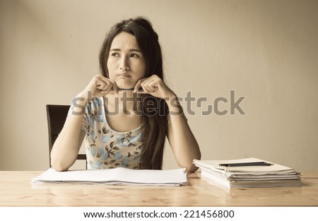 asian Woman is working with paper sheet at the wood table with retro filter