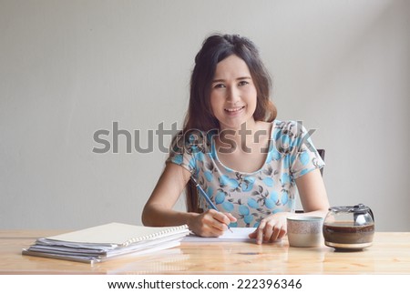 asian Woman is working with paper sheet at the wood table