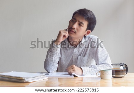 business man working and think with paper sheet at work table