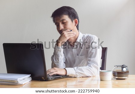 asian depressed business man working with laptop at work table