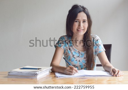 asian Woman is working with paper sheet at the wood table