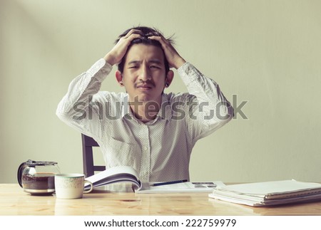asian depressed business man working at work table with retro filter