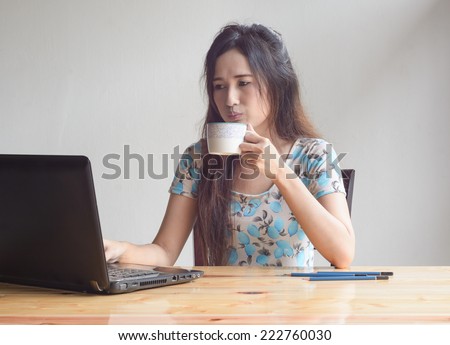 asian business woman working with laptop and drink coffee at table