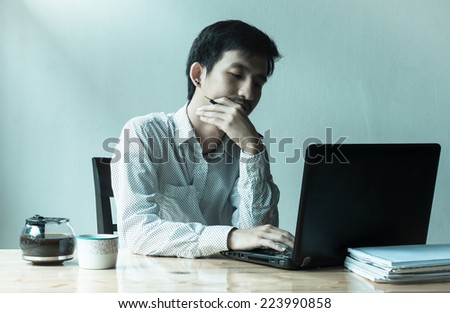 asian depressed business man working laptop at work table with retro filter