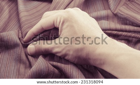 man hand touching cotton fabric textile background with retro filter