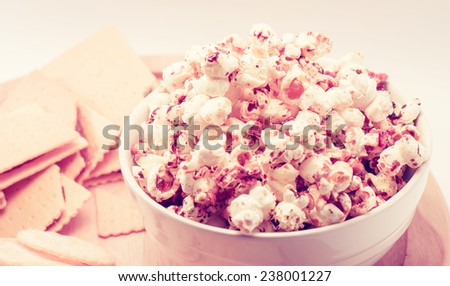 caramel popcorn in bowl with snack food on white