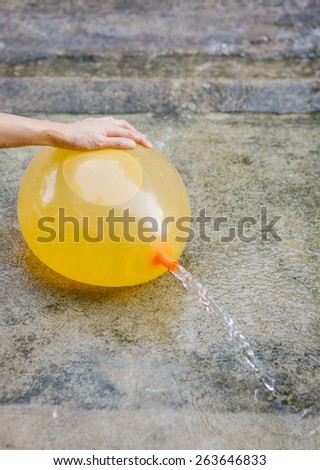 girl hand hold water balloon at outdoor on floor