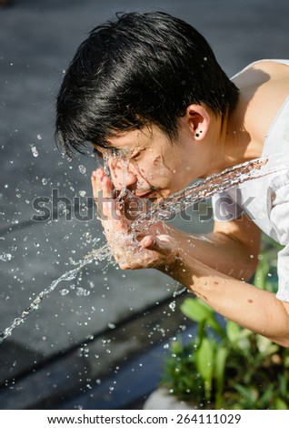 asia man washing him face with Water splash. at outdoor