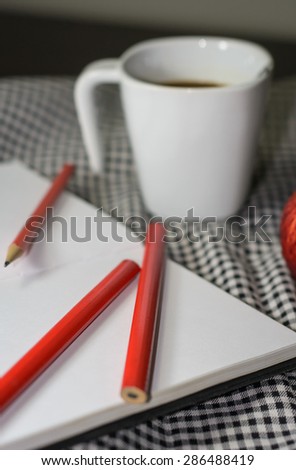 pencil and book on fabric pattern with soft focus