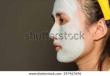 Young asia girl treatment blue facial mask on wall