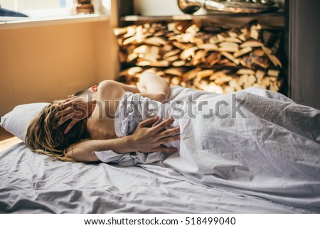 beautiful couple lying together on the bed. the guy hugs the girl in the bed