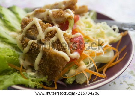 batter fried fish with salad topping with salad dressing