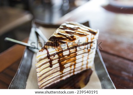 piece of chocolate crepe cake with chocolate sauce