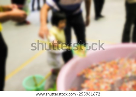 blurry defocused image of kid getting the lucky draw from the pool for background