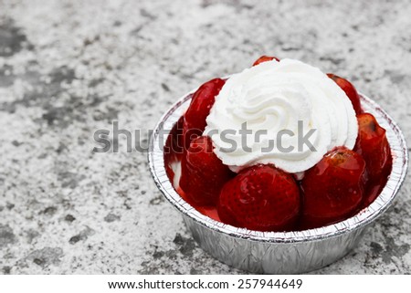 strawberry cheese cake with cream on top on cement floor