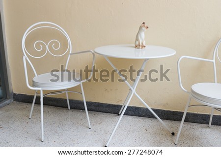 white chair and desk with cat figurine at the corner