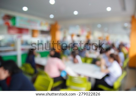 blurry defocused image of people eating food in food court for background