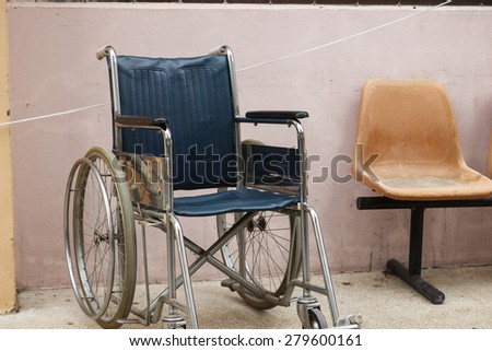 old wheelchair beside the beige wall of the building