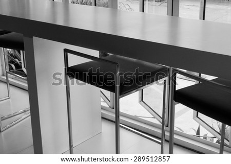 black leather bar stool and counter beside the window, black and white