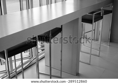 black leather bar stool and counter beside the window, black and white