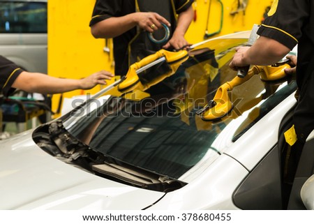 Repairman is repairing windshield of the car