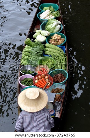 BANGKOK - JULY: A female vendor floats in a boat at the floating market (Damnoen Saduak) on July 18, 2009 near Bangkok. Thousands of Thailand travellers come and visit this scenic attraction every year.