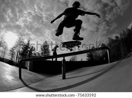 perfect silhouette of a skateboarder doing a flip trick at the skate park.