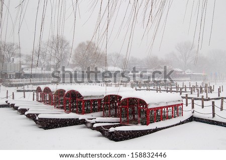 Boats covered with snow in houhai. Houhai lake is surrounded by restaurants, bars and stores. While walking around you can see the traditional hutongs that are fast disappearing in modern Beijing.
