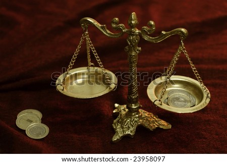 Still-life with old weights and coins on a red background