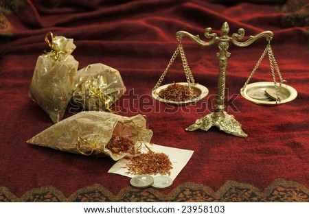 Still-life with old weights, coins and spices of the east on a red background