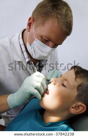The doctor treats a teeth to the child (vertical)
