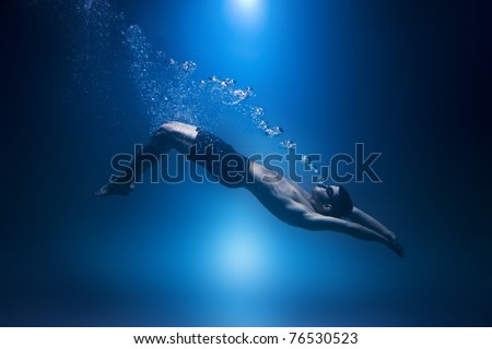 Swimmer underwater isolted exhaling bubbles blue background