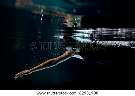 Professional swimmer underwater crawl isolated black background