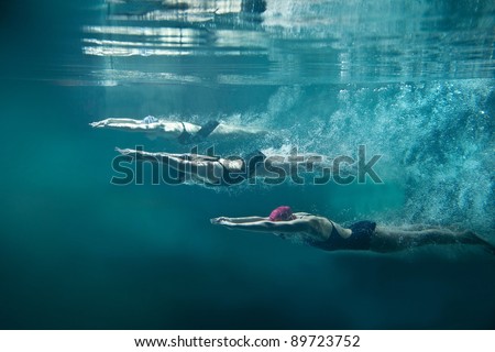 Professional three swimmers under water isolated