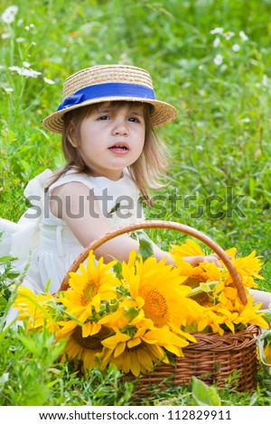 little girl with a big wattled basket with sunflowers