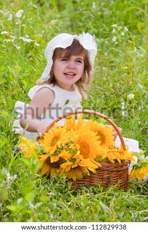 little girl with a big wattled basket with sunflowers