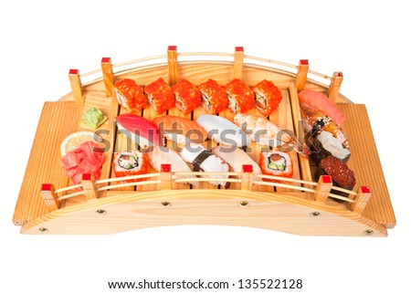 Sushi set with slice of lemon, wasabi and gari on arched wooden plate