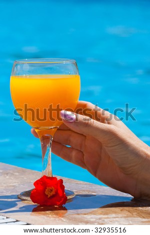 The female hand holds a glass with orange juice