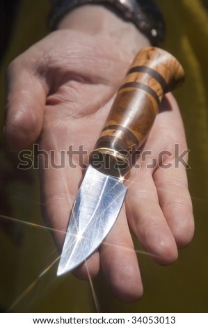 hunting knife on a palm of the man