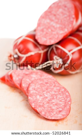 long loaf of smoked sausage lies on chopping board