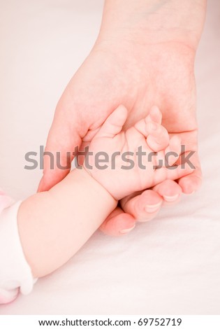 parental hand holds  hand the baby