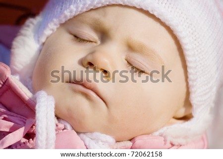 little girl in a pink jacket sleeps in a carriage