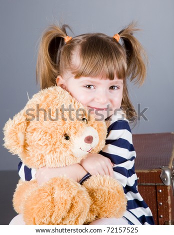 four-year girl sits  with a toy bear