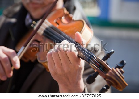 The man plays a violin. Hands of the musician close up.