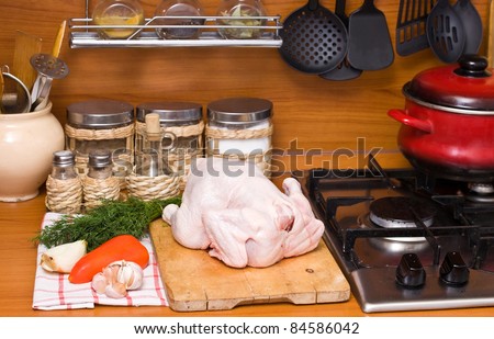 Hen lies on a chopping board. Meal preparation.